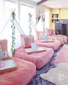 a room filled with lots of pink beds covered in blankets and pillow cases on top of each other