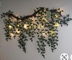 there is a plant with lights on it hanging from the wall in front of a bed