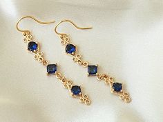 These elegant blue and gold earrings, are perfect for your special occasion! They feature sapphire blue zircon gemstones, in a high quality, 18k gold plated setting.  Product details: * 18k gold plated ear wires; Lead and nickle free * Zircon gemstones * 18k gold plated setting * Handmade, with lots of love and care! - Length:    2 inches - Width:     .25 inches ❤ You can click here to see more unique jewelry from Flutterbird: https://www.etsy.com/shop/FlutterbirdCo My goal is to provide every customer with exceptional service. Please message me if you have any questions. Thank you for supporting my small business!  Please visit my F.A.Q. and shop policy sections for additional info. Elegant Sapphire Crystal Dangle Earrings, Blue Gold-plated Earrings For Wedding, Gold Sapphire Dangle Earrings, Sapphire Drop Crystal Earrings, Elegant Gold-plated Birthstone Earrings, Elegant Gold Plated Birthstone Earrings, Elegant Sapphire Crystal Drop Earrings, Elegant Sapphire Crystal Earrings, Gold Sapphire Drop Earrings