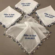 four personalized handkerchiefs with beaded trim and embroidered names on them, all in white