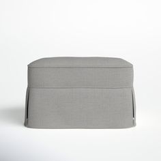 a small grey ottoman sitting on top of a white floor