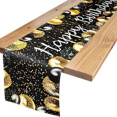 a black and gold birthday table runner with confetti on it