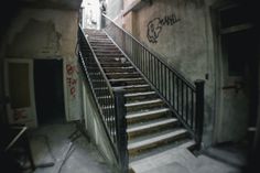 an old building with stairs and graffiti on the walls