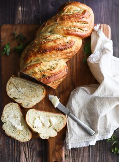 a loaf of bread sitting on top of a cutting board next to slices of bread