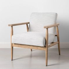 a wooden chair sitting on top of a hard wood floor next to a white wall