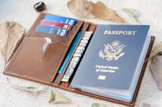 an open passport case sitting on top of a table next to a wallet and money