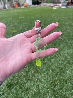 a person's hand holding a green key chain