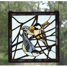 a stained glass window with a bird on it's side and trees in the background