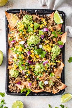 a tray filled with nachos and guacamole on top of it