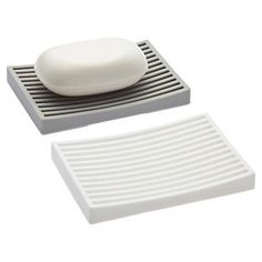 a white soap dish sitting on top of a gray and white tray next to a sponge