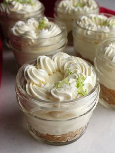 several desserts in small glass jars on a table