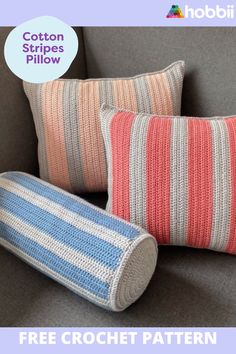 two crocheted pillows sitting on top of a gray couch next to each other