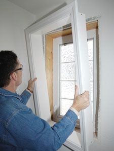 a man is pointing at the window in front of him