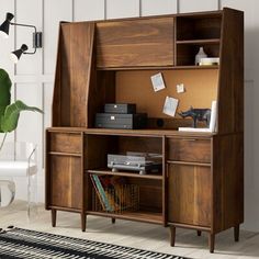 a wooden cabinet with drawers and shelves in the corner next to a rug on the floor