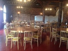 an empty dining room with many chairs and tables set up in rows on red carpeted flooring