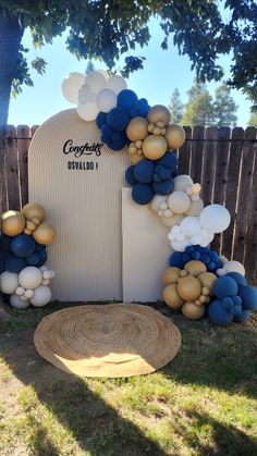 balloons and streamers decorate the back of a white chair in front of a wooden fence