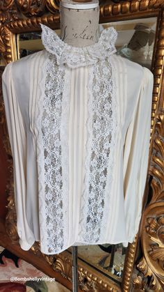 This gorgeous blouse is from the 70's by Designer Oscar de la Renta.  Made of a beige silk and lace. Flat pleats down the front with beautiful white lace insets and collar.  Buttons up the back and cuffs. Full sleeves with button cuffs. Very luxurious. The size has worn away on the tag, however, the best fit would be Large.  Please see the measurements below for a proper fit.  All sales are final. Measurements Armpit-armpit doubled 42" Shoulder 16" Sleeves 24" Length 24" Elegant Lace Patchwork Blouse For Daywear, Feminine Cream Blouse With Lace Cuffs, Elegant Lace Work Blouse For Daywear, Elegant Beige Blouse With Lace Collar, Elegant Beige Blouse With Lace Sleeves, Elegant Beige Lace Top With Lace Sleeves, Elegant Lace Top For Day, Elegant Cream Blouse With Lace Cuffs, Elegant Silk Blouse With Lace Trim