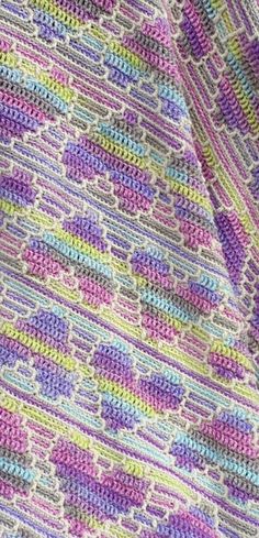 a crocheted blanket is shown with multicolored stripes