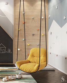 a yellow chair sitting in front of a wall with climbing equipment on it's sides