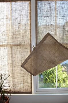 the window is covered in burlap and has a lamp hanging from it's side