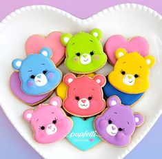 a heart shaped plate filled with cookies decorated like teddy bear's and other bears