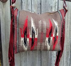 a brown and red pillow hanging on a wooden wall