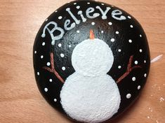 a painted rock with a snowman on it