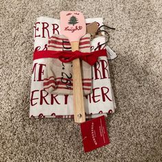 a wooden spatula sitting on top of a white and red towel next to a spoon