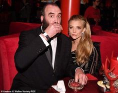 a man and woman sitting at a table with drinks