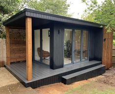 a small black shed with sliding glass doors on the front door and side porch area