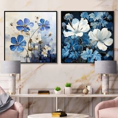 two blue and white paintings on the wall in a living room with pink chairs, coffee table and lamp