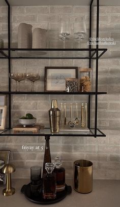 the shelves are filled with different types of glasses and other items on display in front of a brick wall