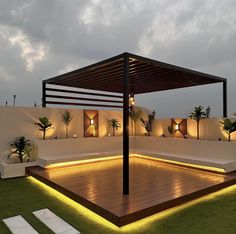 an outdoor patio with lights on the floor and plants in potted pots next to it