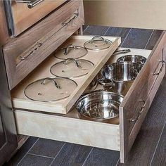 an open drawer with pots and pans in it