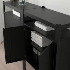 a black cabinet with two doors and some papers