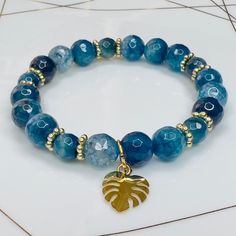 Round Faceted Blue/Turquiose Crackle Agate bracelet with Gold Leaf Charm. Gemstone sizes 10mm and 8mm. Handmade with durable stretch elastic string.  Size 8 inches, approximate. It is believed that the Blue Agate stone helps harmonize your energy. It assists in reducing negative energies, helping you stay relaxed and peaceful. Tranquility & Peace. CARE INSTRUCTIONS:  Take it off before bathing, exercising, swimming. Keep your bracelet in a dry place.  Don't wear it in a wet environment such as a Unique Blue Cheap Bracelets, Cheap Handmade Round Bracelets, Cheap Blue Bracelets For Vacation, Cheap Blue Bracelet For Vacation, Affordable Blue Bracelets With Faceted Beads, Affordable Blue Beaded Round Bracelets, Cheap Handmade Blue Bracelets, Cheap Blue Gemstone Beaded Bracelets, Cheap Blue Crystal Round Bracelet