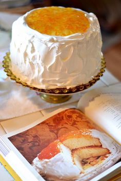 a cake sitting on top of a table next to an open book