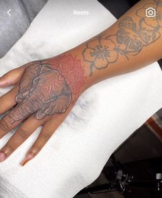 an elephant tattoo on the left hand and right hand, with flowers around its wrist