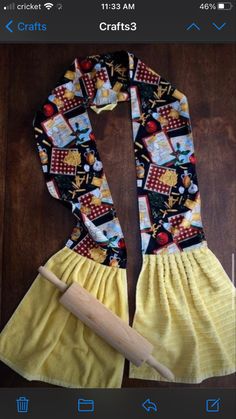 a yellow skirt with black and white pictures on it next to a wooden rolling pin