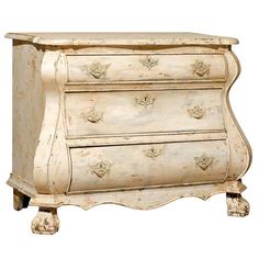 an old white chest of drawers with ornate carvings on the top and bottom, against a white background