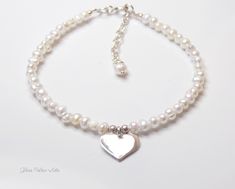 Fall in love all over again with this glimmering silver heart and pearl bracelet....................... White/ Ivory freshwater pearls are AA quality and measure about 2mm Shiny sterling heart measures about 13mm Chain is dainty 925 sterling silver Bracelet is adjustable (choose your size) Bracelet closes with a sterling silver spring clasp This is a handmade item and made for you after the order is placed PACKAGINGAll Jewelry is carefully packaged for a safe arrival and is secured in a jewelry Handmade White Heart-shaped Pearl Bracelet, Pearl White Heart-shaped Pearl Chain Jewelry, White Heart-shaped Bracelet With Pearl Charm, Adjustable White Heart-shaped Pearl Bracelet, Elegant Heart-shaped Pearl Charm Bracelet, Silver Spring, Sterling Silver Bracelet, Sterling Silver Heart, Silver Heart