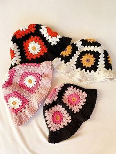 four crocheted hats laying on top of each other