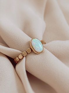 The romantic and gorgeous Oval Opal Ring is the focus of this handmade ring. It’s a Unique white fire opal stone, Man-made opals have fewer flaws and a lighter carbon footprint. This beautiful opal ring is a gift or gift for yourself, it will illuminate your best qualities and bring forth creativity and inspiration. Details: 14K gold filled & sterling silver band: hammered style gemstone: white fire opal measures stone: 6mm x 8mm. measure band: approx 2.3mm - 2.5mm shape: oval Opal Meaning: hope Opal Ring Designs Unique, Opal Gemstone Ring, Fire Opal Rings, Small Opal Ring, Opal And Pearl Ring, Oval Stone Ring Design, Ring Stone Design, Stone Ring Design Gold, Opal Ring Designs