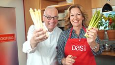 a man and woman are holding asparagus in their hands while posing for the camera