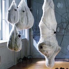 two bats hanging from the ceiling in front of a window