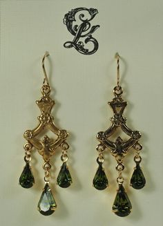 Victorian inspired earrings, with beautiful detailed antique reproduction flower stampings and Olive green triple teardrop Swarovski crystals.  Size: 1 1/2" long x 5/8" wide (38mm x 19mm) earrings dangle from gold-filled, nickel free ear wires.  They are extremely light in weight, but so elegant and fashionable.  Great earrings for brides, bridesmaids and birthstone colors.   Match these to anything in your wardrobe, with the 12 additional Swarovski colors available.   Here are some other handcrafted Victorian style earrings: www.etsy.com/listing/1356432979; www.etsy.com/listing/259206428; www.etsy.com/listing/209124132; www.etsy.com/listing/224373182; www.etsy.com/listing/261391169; www.etsy.com/listing/202956738; www.etsy.com/listing/258330603.  Thank you for visiting my shop. Purchase i Elegant Green Chandelier Earrings With Intricate Design, Victorian Green Earrings For Wedding, Vintage Green Jeweled Earrings, Victorian Green Drop Earrings, Ornate Green Earrings With Intricate Design, Victorian Green Dangle Earrings, Green Victorian Dangle Earrings, Green Filigree Teardrop Earrings, Green Teardrop Filigree Earrings