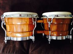 two wooden drums sitting on top of a brown couch