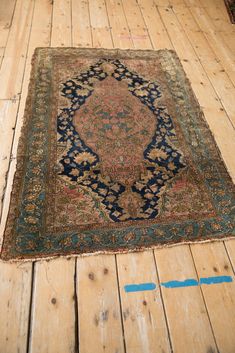 an old rug is laying on the floor in a room with wooden floors and boards