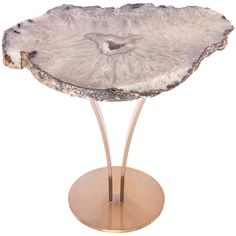 a large piece of rock on a stand with a metal base and gold plated legs