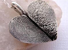 two fingerprints are attached to a silver necklace